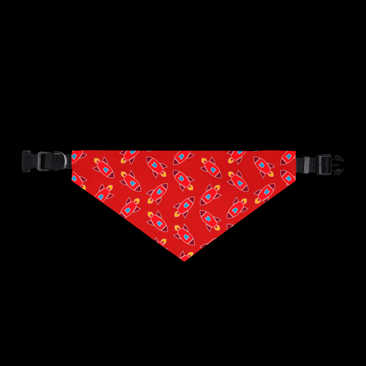 A red pet bandana with a repeating pattern of colorful rockets, shown flat with black plastic buckles on both ends.