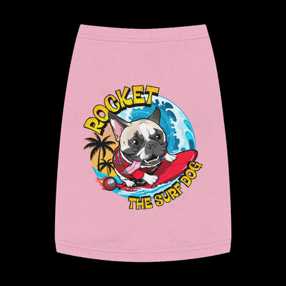 A pink pet shirt featuring a colorful graphic of a French Bulldog surfing on a red board with the text 'ROCKET THE SURF DOG' in yellow and blue.