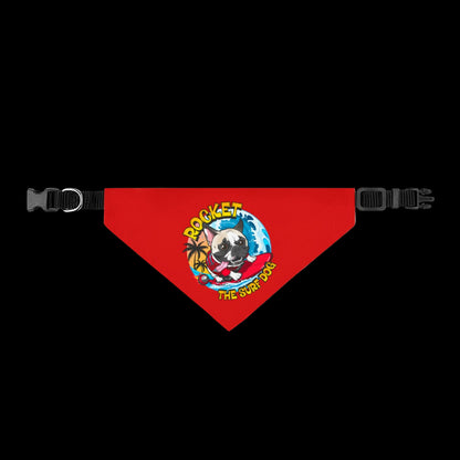 A red triangular pet bandana with black adjustable plastic buckles on both sides. The center features a colorful graphic of a pug dog wearing a red bow tie and sunglasses, surrounded by a blue globe and yellow text that reads 'ROCKET THE SURF DOG'.
