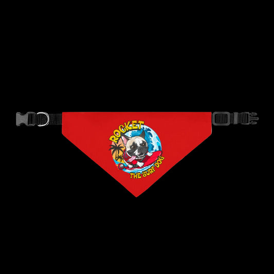A red triangular pet bandana with black adjustable plastic buckles on both sides. The center features a colorful graphic of a pug dog wearing a red bow tie and sunglasses, surrounded by a blue globe and yellow text that reads 'ROCKET THE SURF DOG'.