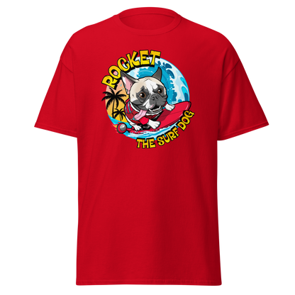 A red short-sleeve crewneck t-shirt featuring a colorful graphic print of a French Bulldog surfing on a red surfboard with the text 'ROCKET THE SURF DOG' in yellow.