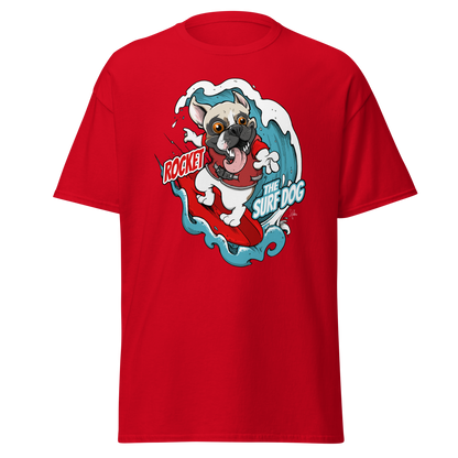 A red short-sleeve crewneck t-shirt featuring a colorful graphic print of a French Bulldog surfing on a red surfboard with the text 'ROCKET THE SURF DOG.'
