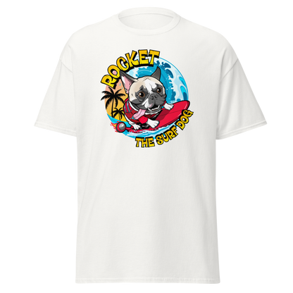 A white short-sleeve crewneck t-shirt featuring a colorful graphic print of a French Bulldog surfing on a red surfboard with the text 'ROCKET THE SURF DOG' in yellow.