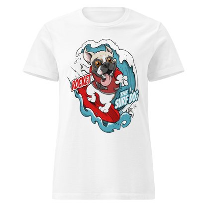 A white short-sleeve crewneck t-shirt featuring a cartoon graphic of a white French Bulldog surfing on a red board with blue waves, accompanied by the text 'ROCKET THE SURF DOG'.